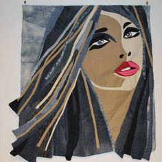 a woman's face is depicted on a piece of denim with strips of fabric covering it