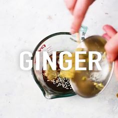 someone is pouring ingredients into a blender with the words ginger on it and in front of them