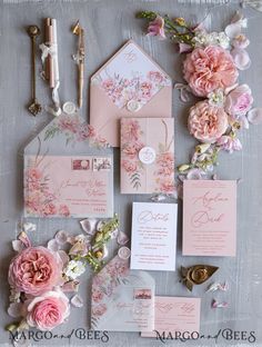 the wedding stationery is laid out with pink flowers