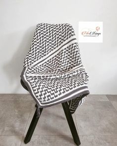 a black and white blanket sitting on top of a chair