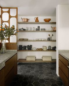 a kitchen with open shelving and counter tops