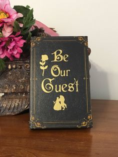 a wedding guest book sitting on top of a table next to a vase with flowers