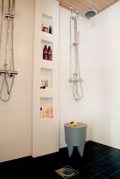 a bathroom with black tile flooring and white walls, including a walk in shower