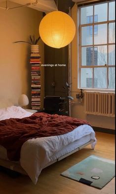 a bedroom with a bed, rugs and lamp in it's center area