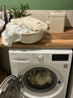 a white washer sitting on top of a wooden counter next to a dryer