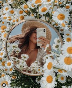 a woman taking a selfie in front of a mirror surrounded by daisies