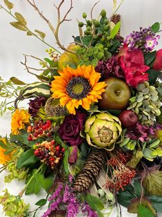 an arrangement of flowers and foliage on a white background