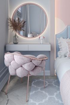 a bedroom with a bed, mirror and vanity in the corner next to it is a pink chair