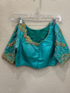 ❥ Handmade Designer stitched blouse ; Can be used for sarees / Lehengas. ❥ Ready to ship (Price mentioned is for Size 34-38)  ❀❀ Return / Exchange Policy :  ※ No Return/ No Exchange / No Cancellation! ※We need proof of video while package is opening for considering any case of missing or damaged products ;  ※ We can not accept any returns , if video at the time of package opening is not provided by the client . ღ ღ Please be courteous and don't ask for negotiation on prices ! We define prices ba Green Blouse For Wedding And Transitional Seasons, Transitional Green Blouse For Wedding, Elegant Fitted Blouse Piece In Dola Silk, Transitional Fitted Saree With Mirror Work, Transitional Wedding Blue Blouse, Elegant Blouse With Resham Embroidery For Navratri, Elegant Resham Embroidery Blouse For Navratri, Unstitched Resham Embroidery Designer Blouse, Bollywood Art Silk Blouse Piece For Transitional Season