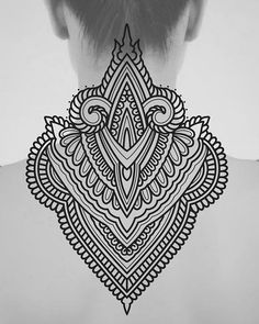 the back of a woman's neck with an intricate tattoo design on her chest