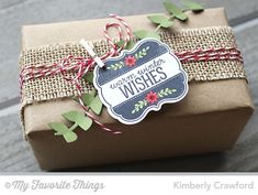 a gift wrapped in brown paper with red and green twine on it's side