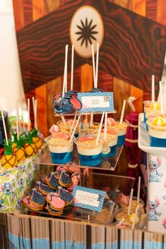 an assortment of cupcakes and desserts displayed on a table