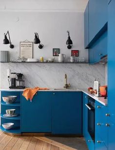 a kitchen with blue cabinets and wooden floors