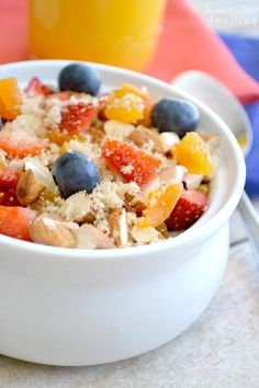 a white bowl filled with cereal and fruit