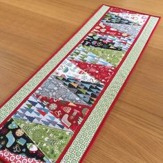 a table runner made out of quilts on top of a wooden table