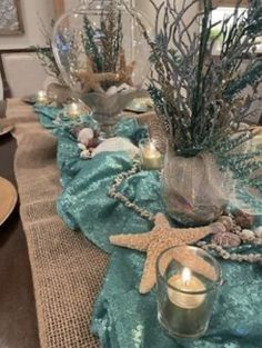 the table is set with candles and seashells