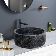 a marble sink in front of a round mirror