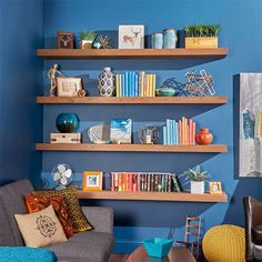 a living room with blue walls and wooden shelves filled with books, vases and other decorative items