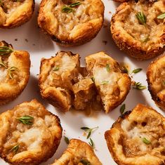 several small pastries are arranged on a white plate with green garnishes