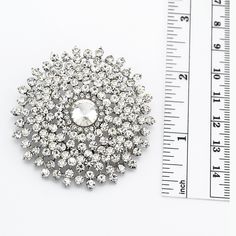 Gorgeous crystal stone brooch, which can be used for your DIY project - wedding, bridal brooch bouquet, dress sash, cake and frame decorations, pillow and clutch decor, crafts, scrap booking, jewelry gift and much more. Size: 2 1/4 inches wide 2 1/4 inches high Stones color: Clear Metal: Silver plated This silver rhinestone brooch can be ordered with pin in the back to wire into brooch bouquet, add to wedding gown or dress sash, or any number of other craft projects or without the pin as a flat Silver Rhinestone Brooches For Wedding, Silver Wedding Brooches With Rhinestones, Elegant Round Crystal Brooches, Silver Crystal Pins For Wedding, White Crystal Brooches For Wedding, Silver Crystal Wedding Pins, Wedding Crystal Pins With Rhinestones, Wedding Brooches With Rhinestones, White Crystal Wedding Brooches