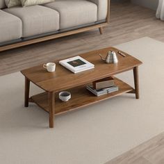 a living room with a couch, coffee table and books on the floor in front of it