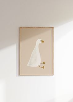 a white duck sitting on top of a wooden floor next to a wall mounted art piece