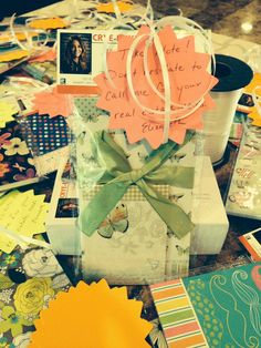 a gift wrapped in paper and tied with a green ribbon on top of a table