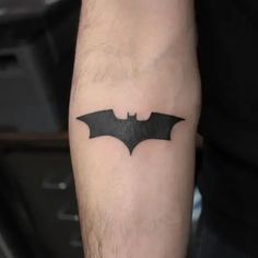 a man's arm with a batman symbol tattoo on the left side of his arm