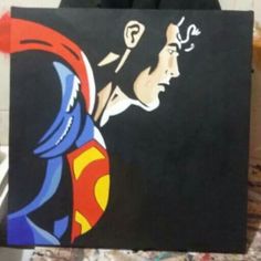 a person holding up a painting with superman on it