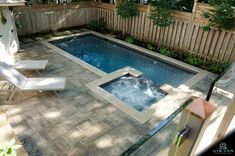 a small backyard with a pool and hot tub in the middle, surrounded by trees