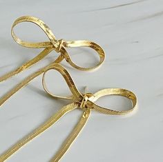 These Long Drop Bow Earrings are a stylish addition to any outfit. With a modern and simplistic design, they are perfect for adding a touch of charm to your look. Their unique shape and long length make them stand out, making you feel sophisticated and chic. Dimensions: approximately 1.5" x 3" 18k gold plated Brass Lead and Nickel free Made in China Pink Pigeon, Ring Bag, Hair Setting, Simplistic Design, Earrings In Gold, Bow Earrings, Scarf Jewelry, Scrunchie Hairstyles, Hair Accessories Headbands