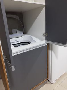 a washer and dryer are in the corner of a room with tile flooring