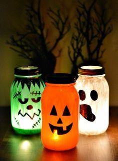 three mason jars decorated with halloween pumpkins and jack - o'- lantern faces