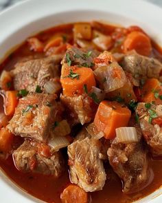 a white bowl filled with stew and carrots