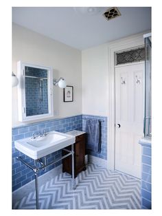 a bathroom with blue and white tiles on the walls, flooring and sink area