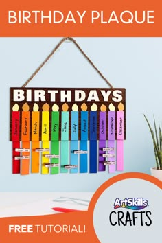 a birthday plaque hanging on a wall with colorful crayons in front of it