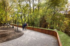 two people walking down a path in the park