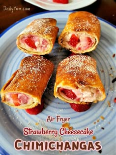 four pastries on a plate with strawberries and powdered sugar in the middle