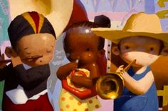 three figurines with hats and instruments in front of a wall painted by children