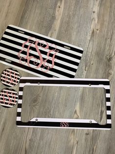 the license plate frame is black and white with pink monogrammed letters on it