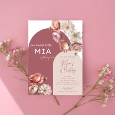 a pink and white wedding card with flowers on the front, next to it is an envelope that says our sweet little mia