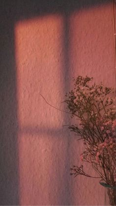 a vase filled with flowers sitting on top of a wooden table next to a window