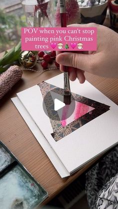 a person holding a piece of paper with the words pov when you can't stop painting pink christmas trees