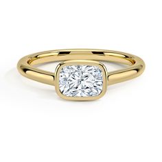 a yellow gold engagement ring with a square cut diamond in the center, on a white background