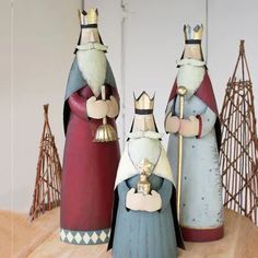 three ceramic figurines sitting on top of a wooden table