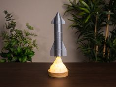 a lit up rocket ship sitting on top of a wooden table