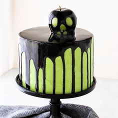 a black and green cake with an apple on top