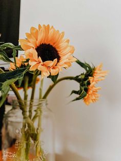 two vases filled with yellow flowers on top of a table