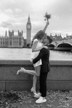 a man and woman are kissing in front of the river thames with big ben in the background