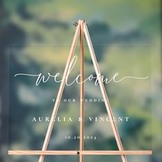 a wooden easel with the word welcome written on it and an arrow in the middle